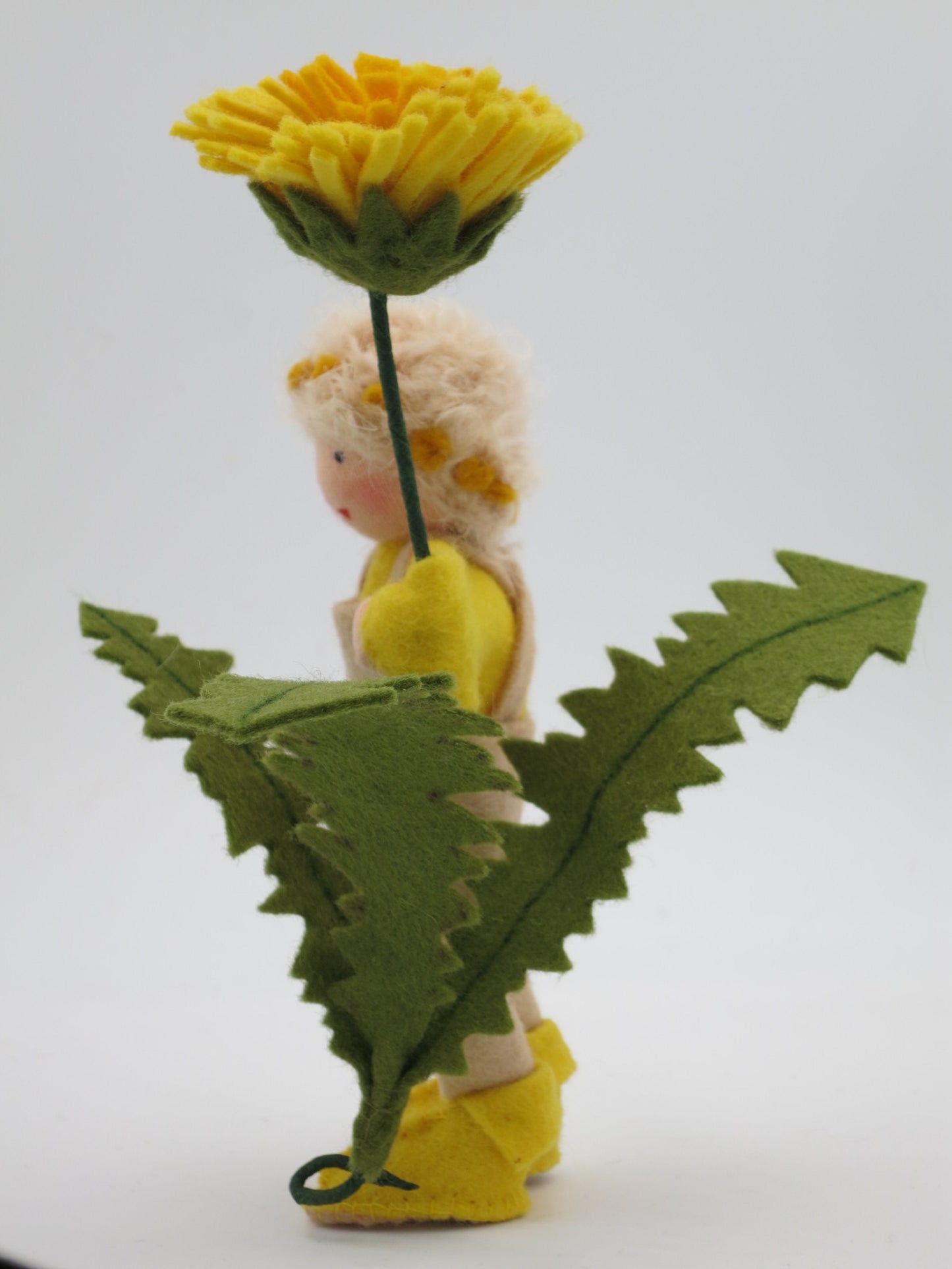 Löwenzahn-Junge Blumenkind auf gelb-grünem Tuch am Sommer-Jahreszeitentisch