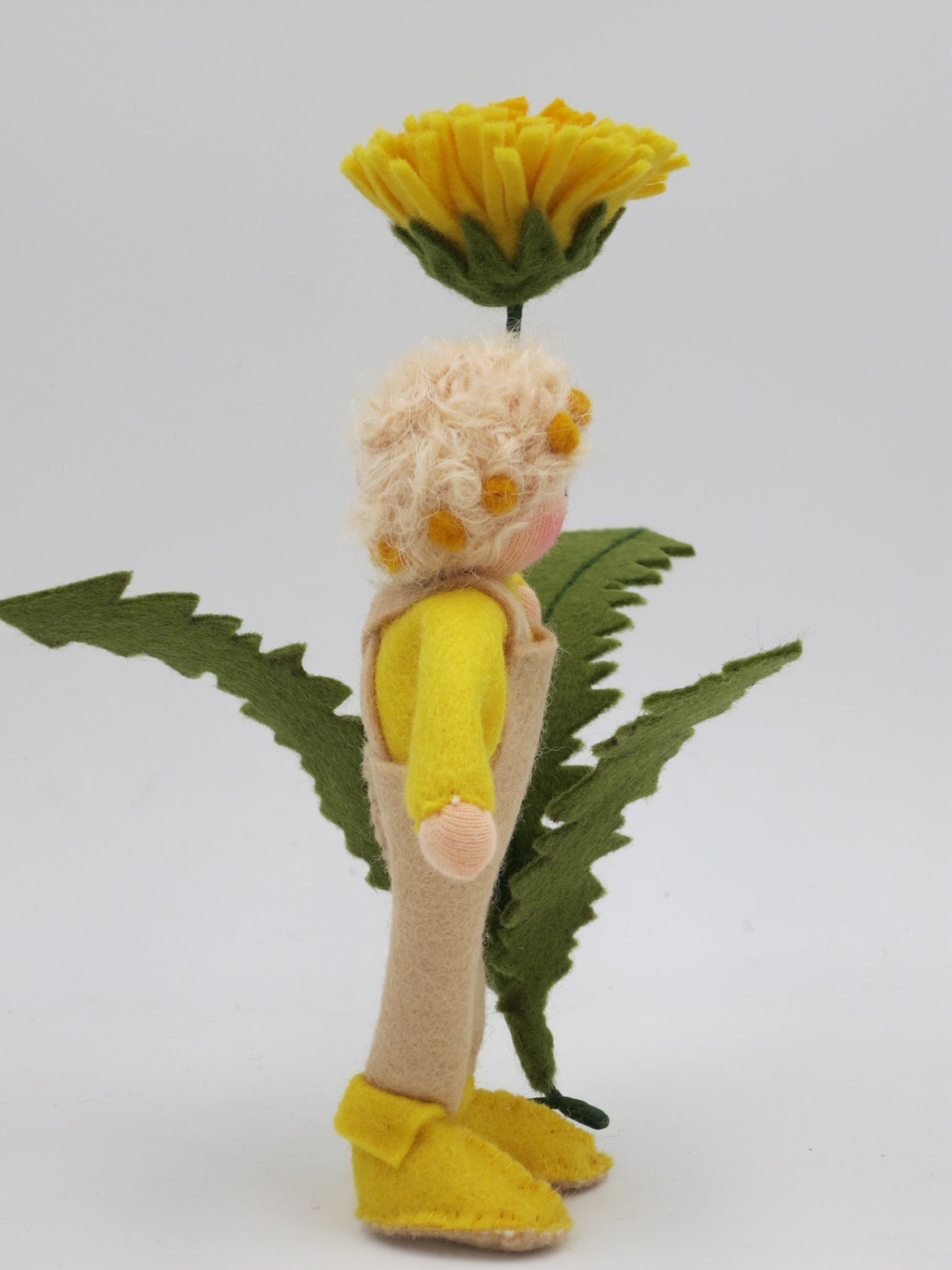 Rückansicht des Löwenzahn-Jungen Waldorf-Blumenkindes mit Blütenkranz im Haar