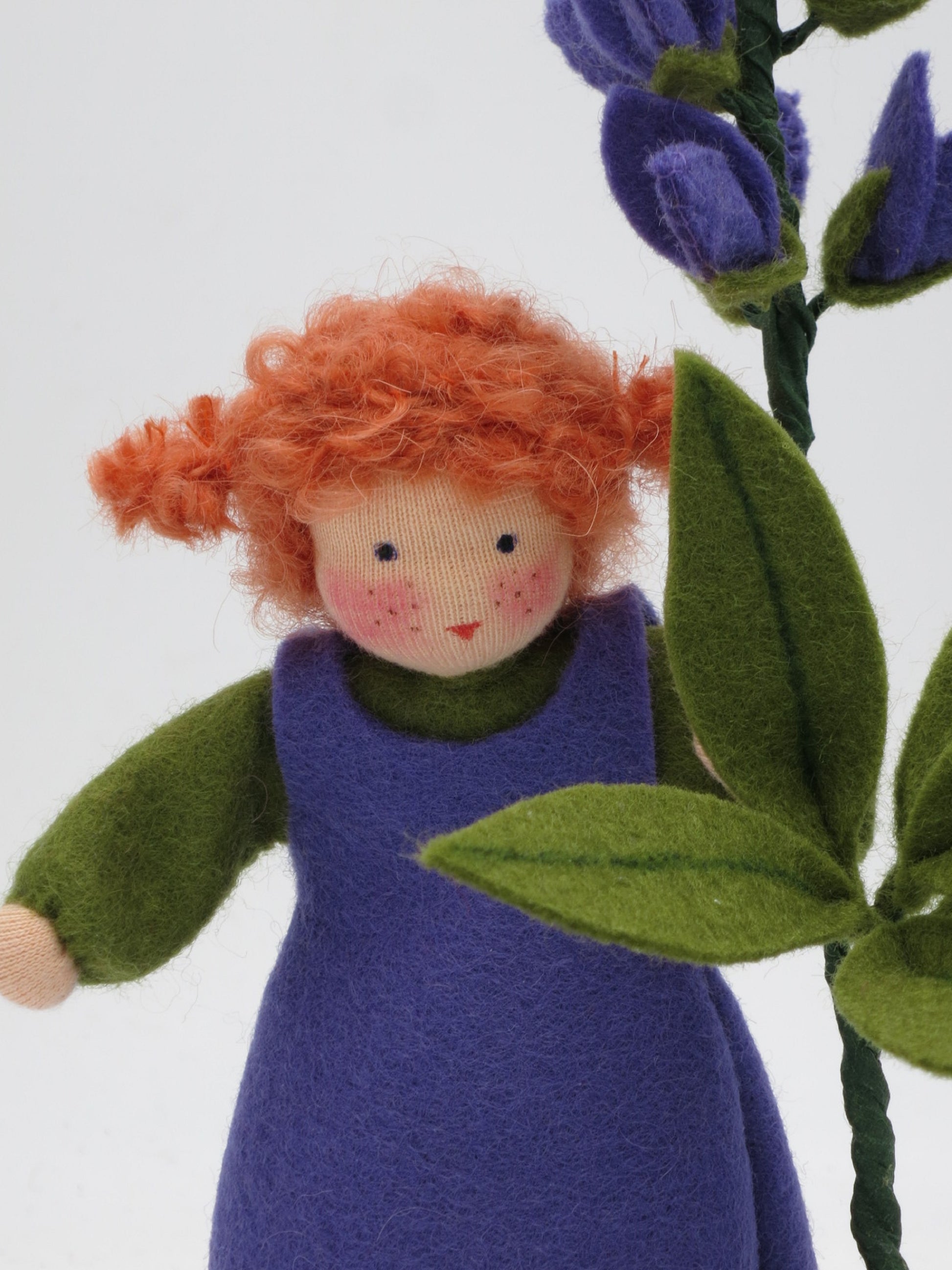 Nahaufnahme des Gesichts vom Lupine-Blumenkind mit roten Locken