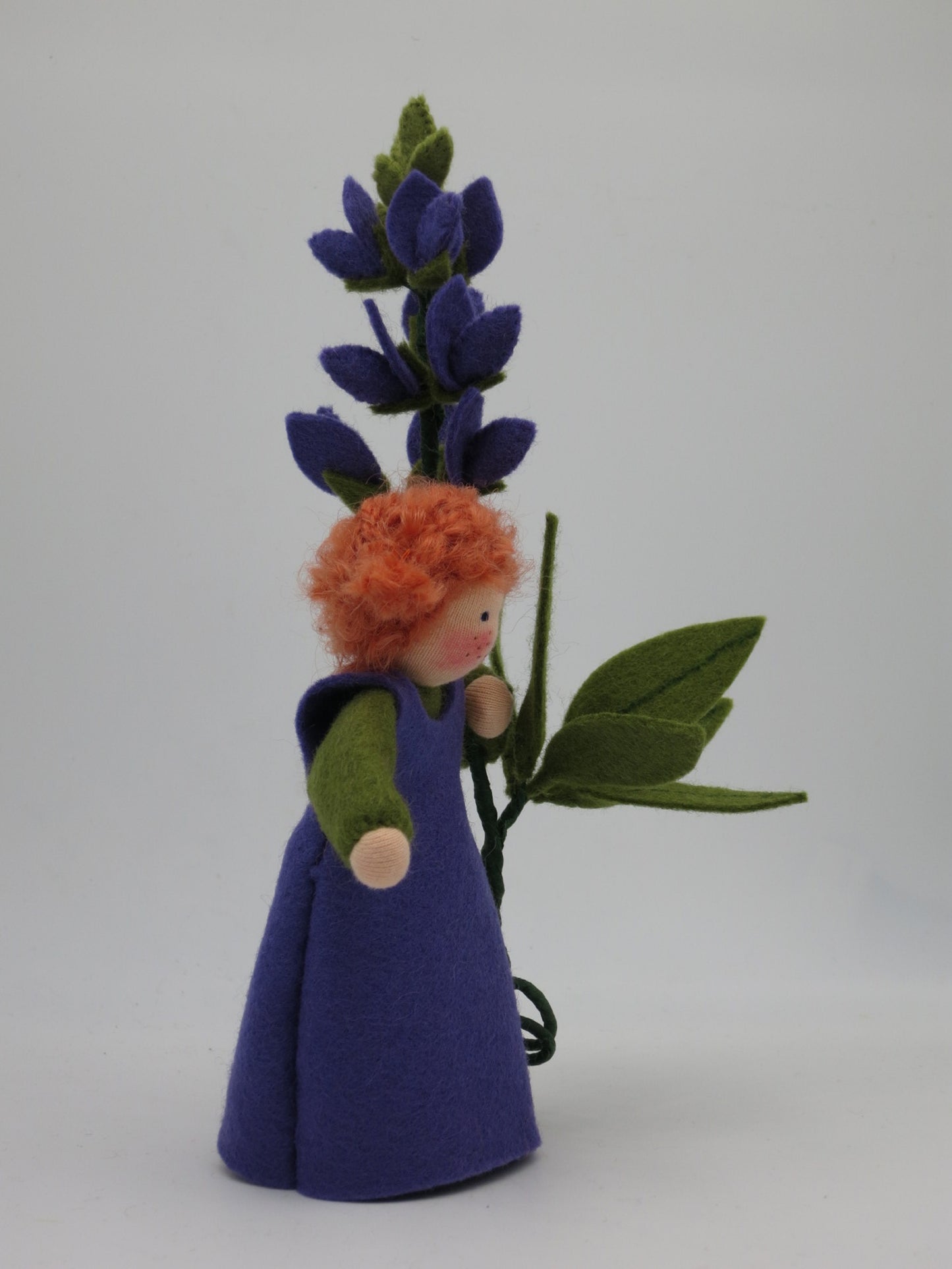 Rückansicht des Lupine-Waldorf-Blumenkindes mit Blütenkerze