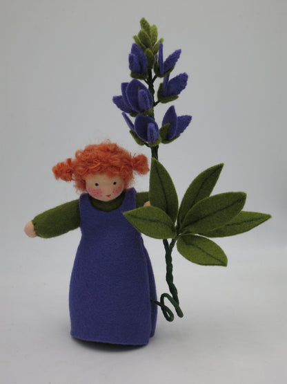Lupine Waldorf-Blumenkind mit roten Zopfhaaren neben violetter Lupinenblüte