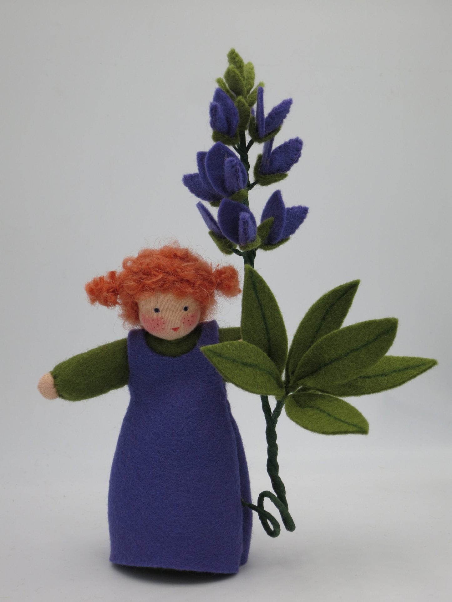 Lupine Blumenkind aus Wollfilz für den Waldorf Jahreszeitentisch, mit violetter Blütenkerze und siebenteiligem Blatt