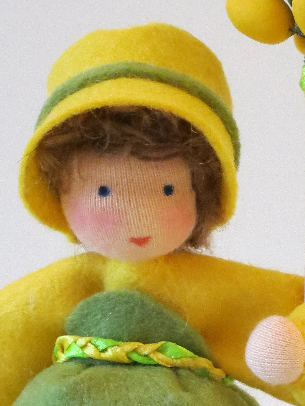 Gesicht des Blumenkindes Mädchen mit Osterbaum, Nahaufnahme Wollfilz Waldorfpuppe