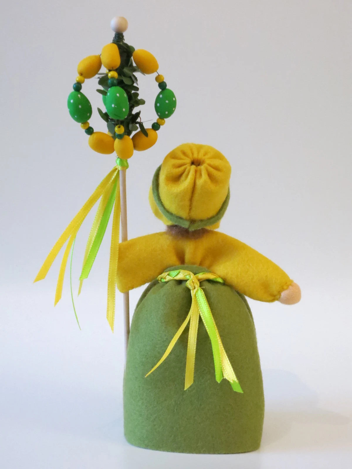Rückansicht des Waldorf Blumenkindes Mädchen mit Osterbaum mit gelber Filzhaube