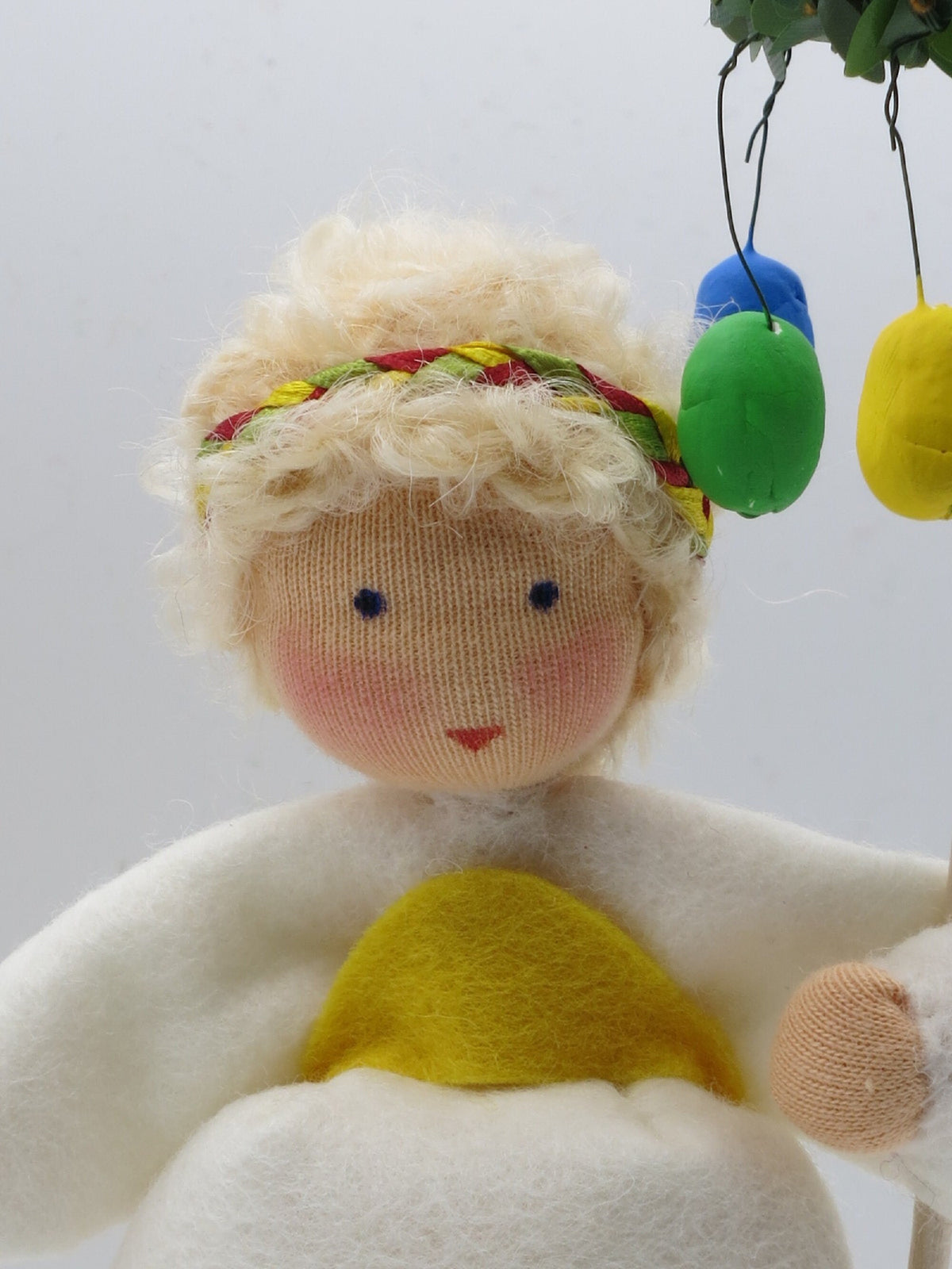 Blondes Osterkranz-Blumenkind, Nahaufnahme von Haarband und hängenden Filz-Ostereiern