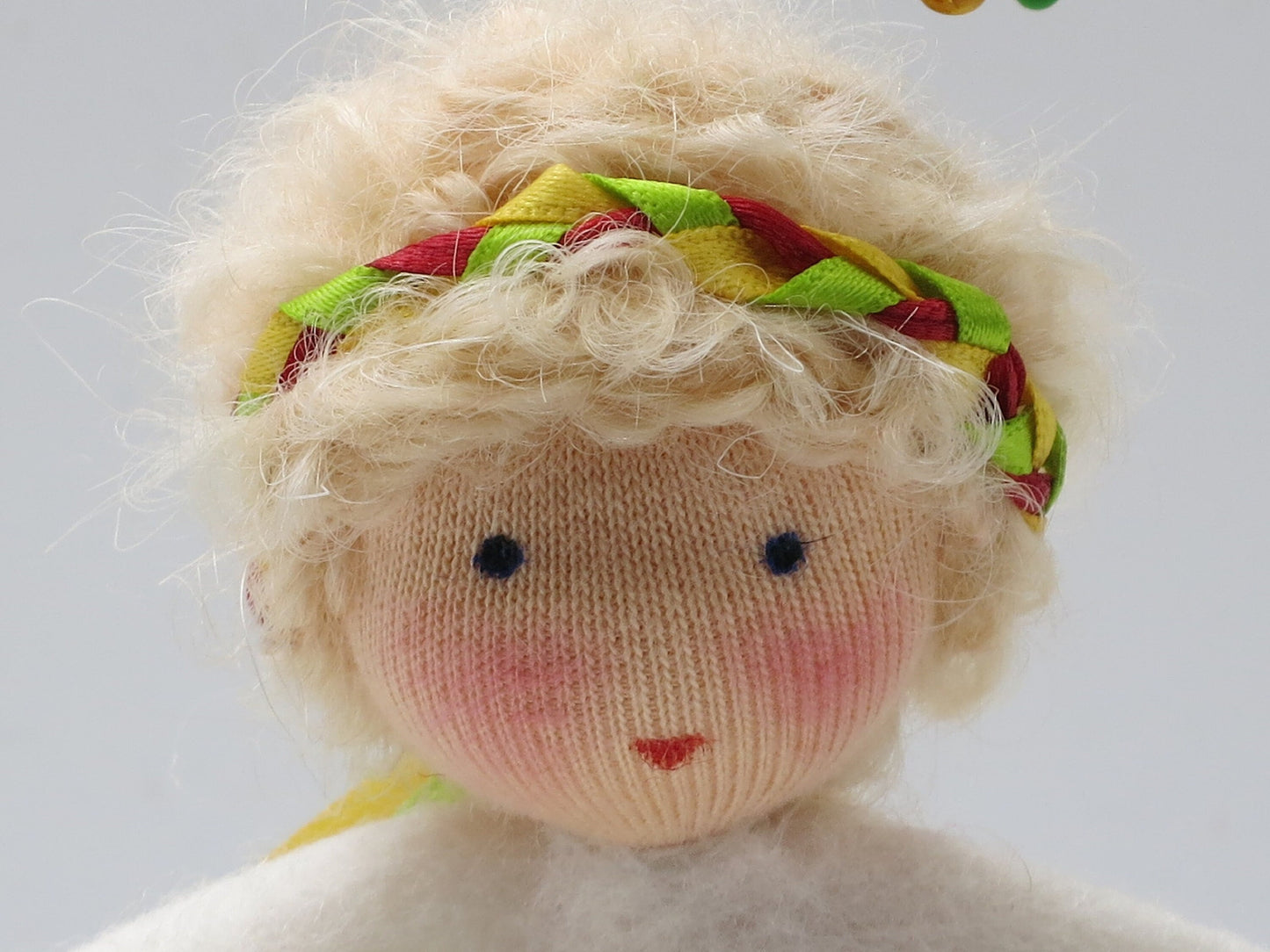 Porträt des Osterkranz-Blumenkinds mit blondem Lockenhaar und geflochtenem Bändchen-Haarband
