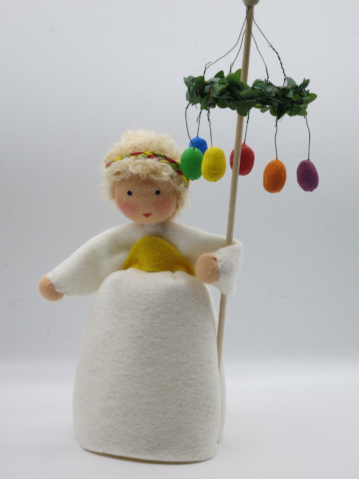 Mädchen mit Osterkranz Blumenkind in weißem Kleid mit Osterkranz und bunten Eiern am Stab
