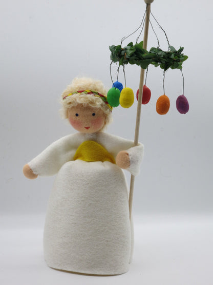 Mädchen mit Osterkranz Blumenkind in weißem Kleid mit Osterkranz und bunten Eiern am Stab