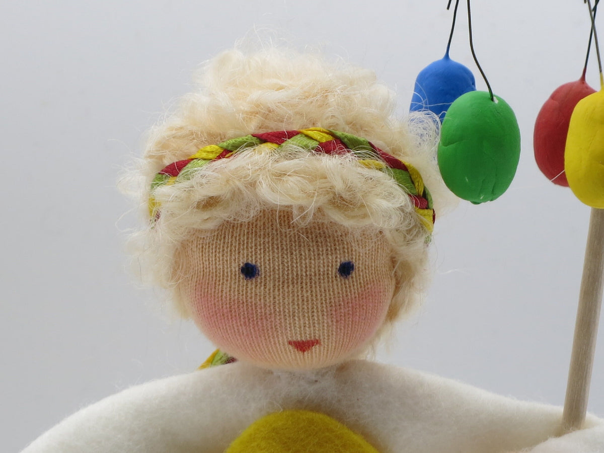 Gesicht des Osterkranz-Blumenkindes mit blonden Locken und Haarband, Nahaufnahme