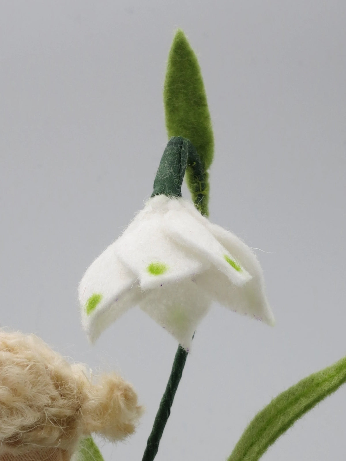 Detailansicht der weißen Märzenbecher-Blüte aus Filz mit den typischen grünen Punkten an den Blütenspitzen