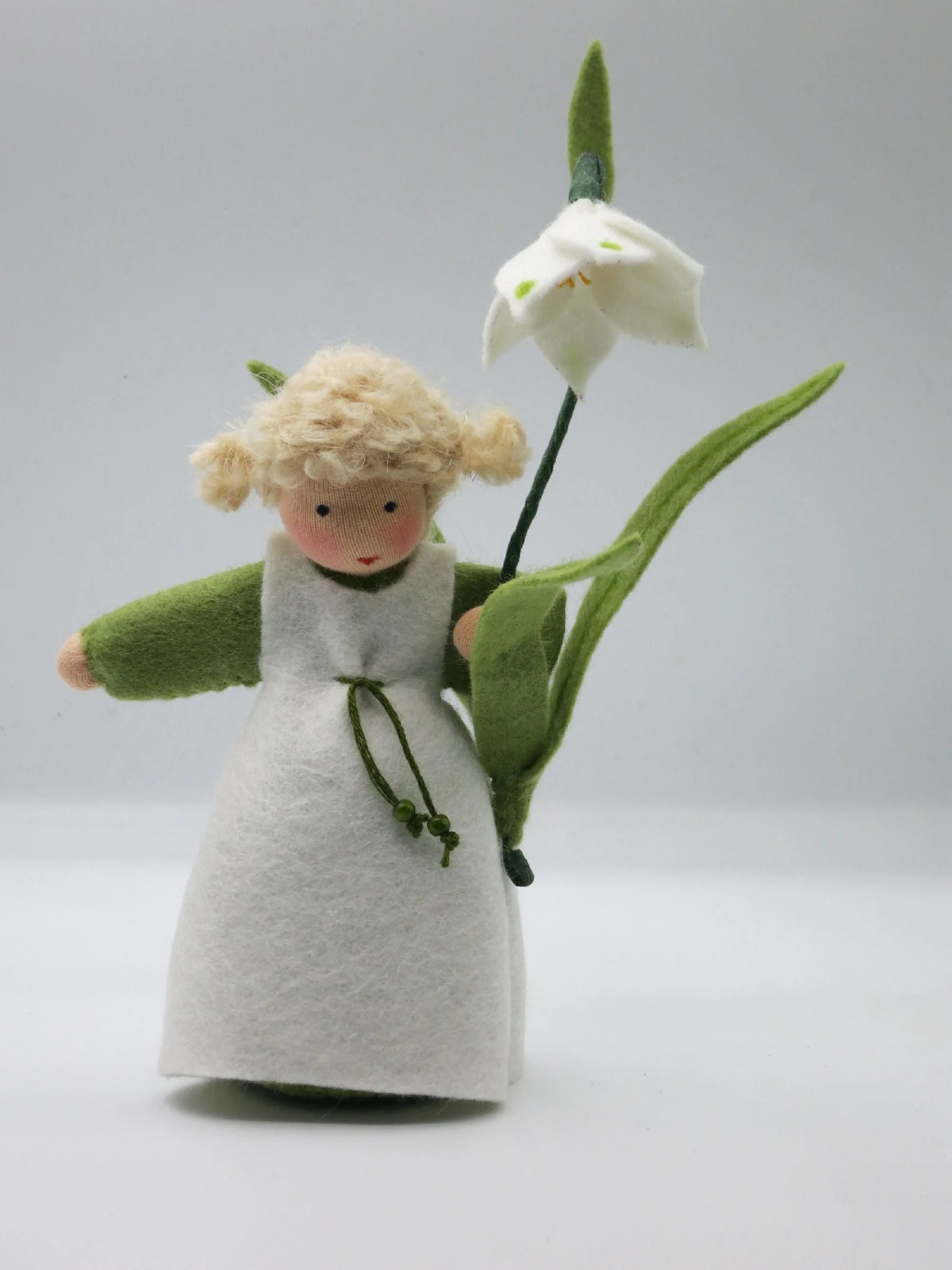 Frontalansicht des Märzenbecher-Blumenkinds mit blondem Zopfhaar und weißer Filzblüte