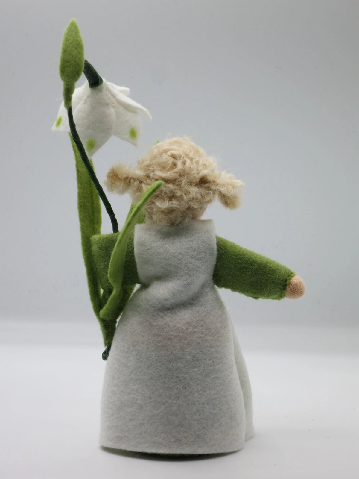 Rückansicht des Märzenbecher-Blumenkinds mit langen grünen Filzblättern und blondem Haar