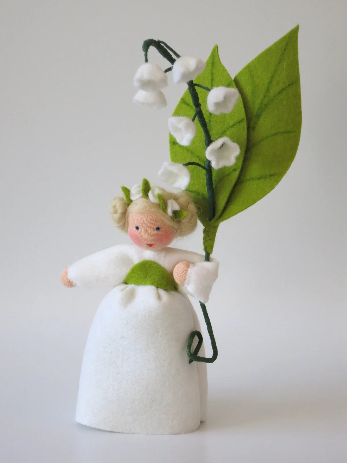 Maiglöckchen-Blumenkind mit Blütenkranz im Haar und weißen Glockenblüten am grünen Blattzweig