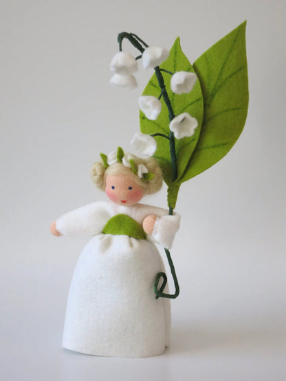 Maiglöckchen-Blumenkind mit Blütenkranz im Haar und weißen Glockenblüten am grünen Blattzweig