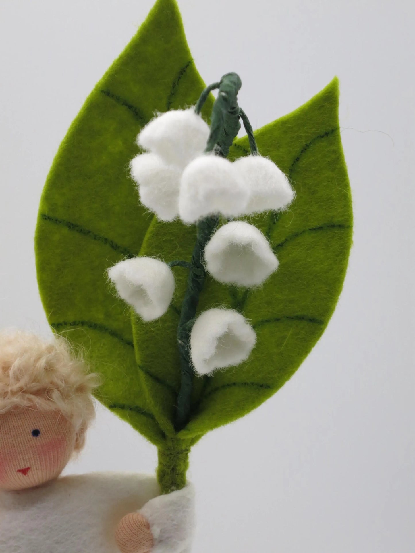 Detailansicht der weißen Maiglöckchenblüten aus Filz mit grünem Blatt