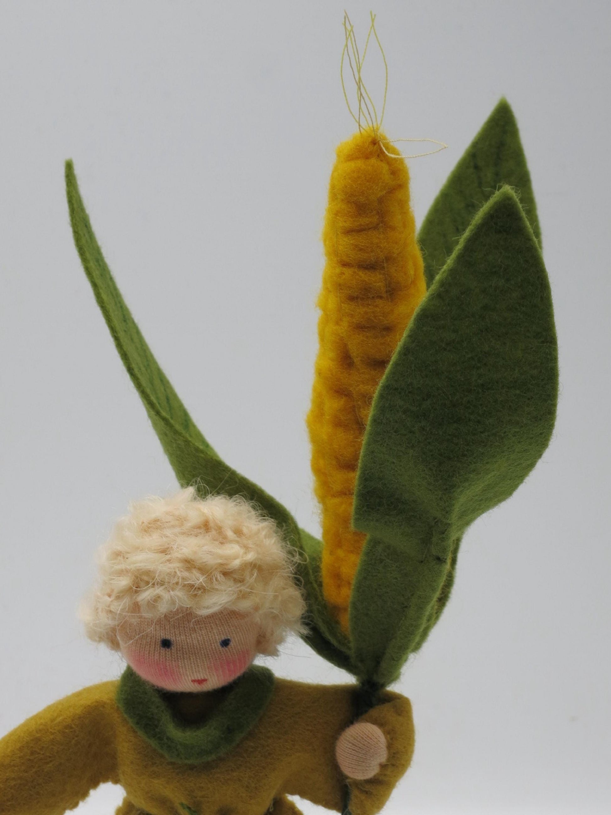 Mais-Junge Blumenkind aus Wollfilz, Nahaufnahme Maiskolben mit gruenen Huellblaettern, Waldorf-Jahreszeitentisch, Art. HE15
