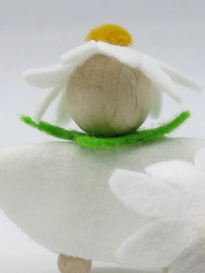 Porträt des Margeriten-Blumenkinds mit naturbelassenem Holzkopf, weißer Blütenhaube und grünem Filzkragen.