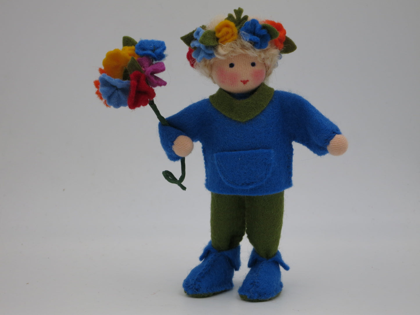 Gesamtansicht des Mittsommer-Jungen mit blauem Filzoberteil und Blütenstrauß, Waldorf Jahreszeitentisch.