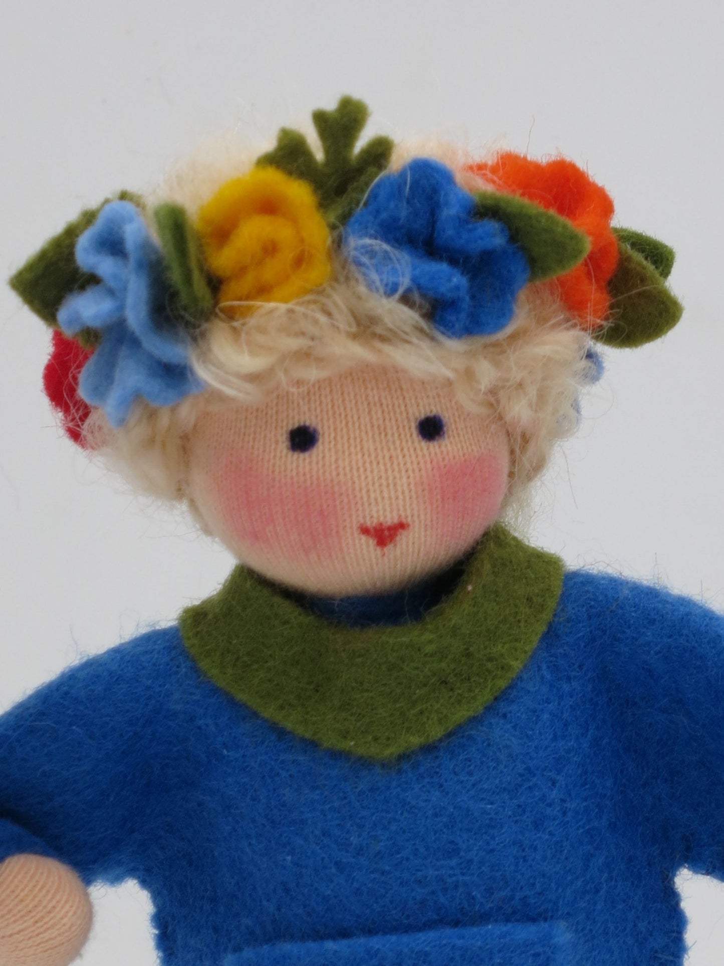 Nahaufnahme des Gesichts vom Mittsommer-Jungen mit Blumenkranz im blonden Lockenhaar.