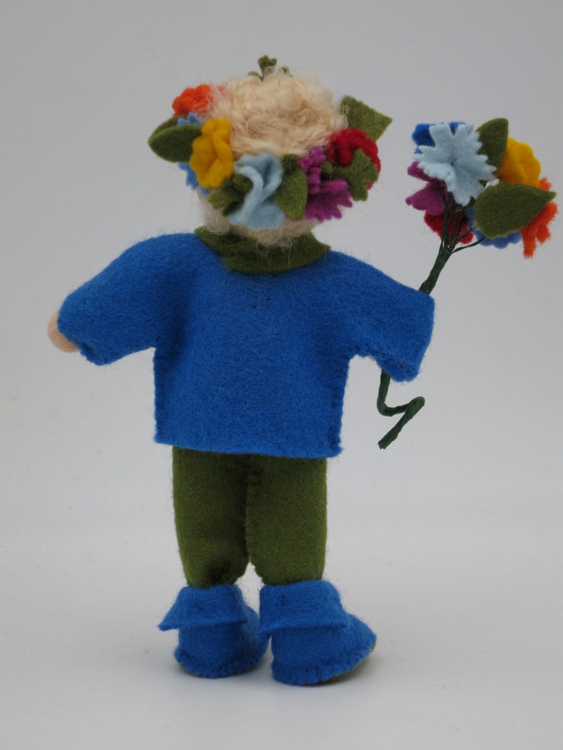Rückansicht des Mittsommer-Jungen mit Blumenkranz aus rotem, gelbem, blauem und orangem Filz.