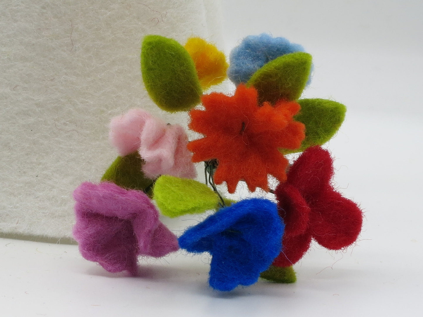 Detailaufnahme des bunten Filz-Blumenstraußes am Mittsommer-Püppchen