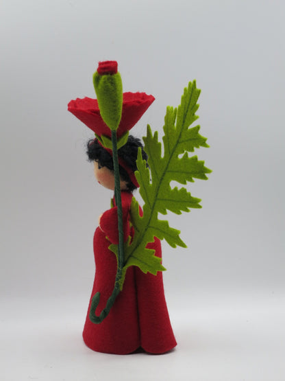 Seitenansicht des Mohn-Blumenkinds mit geschwungener Rankenspirale am Stiel.