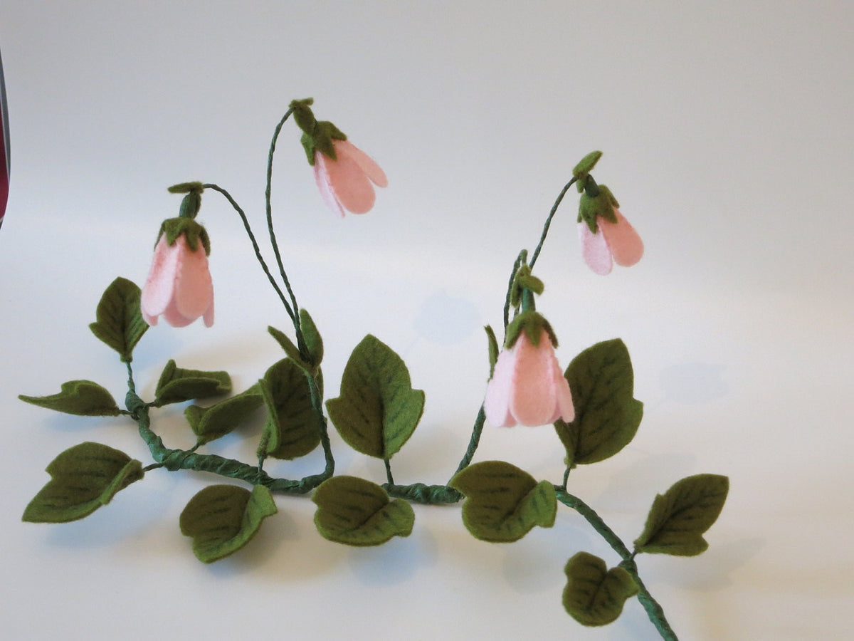 Detailaufnahme der paarweise wachsenden rosa Moosglöckchen-Blüten aus Filz.