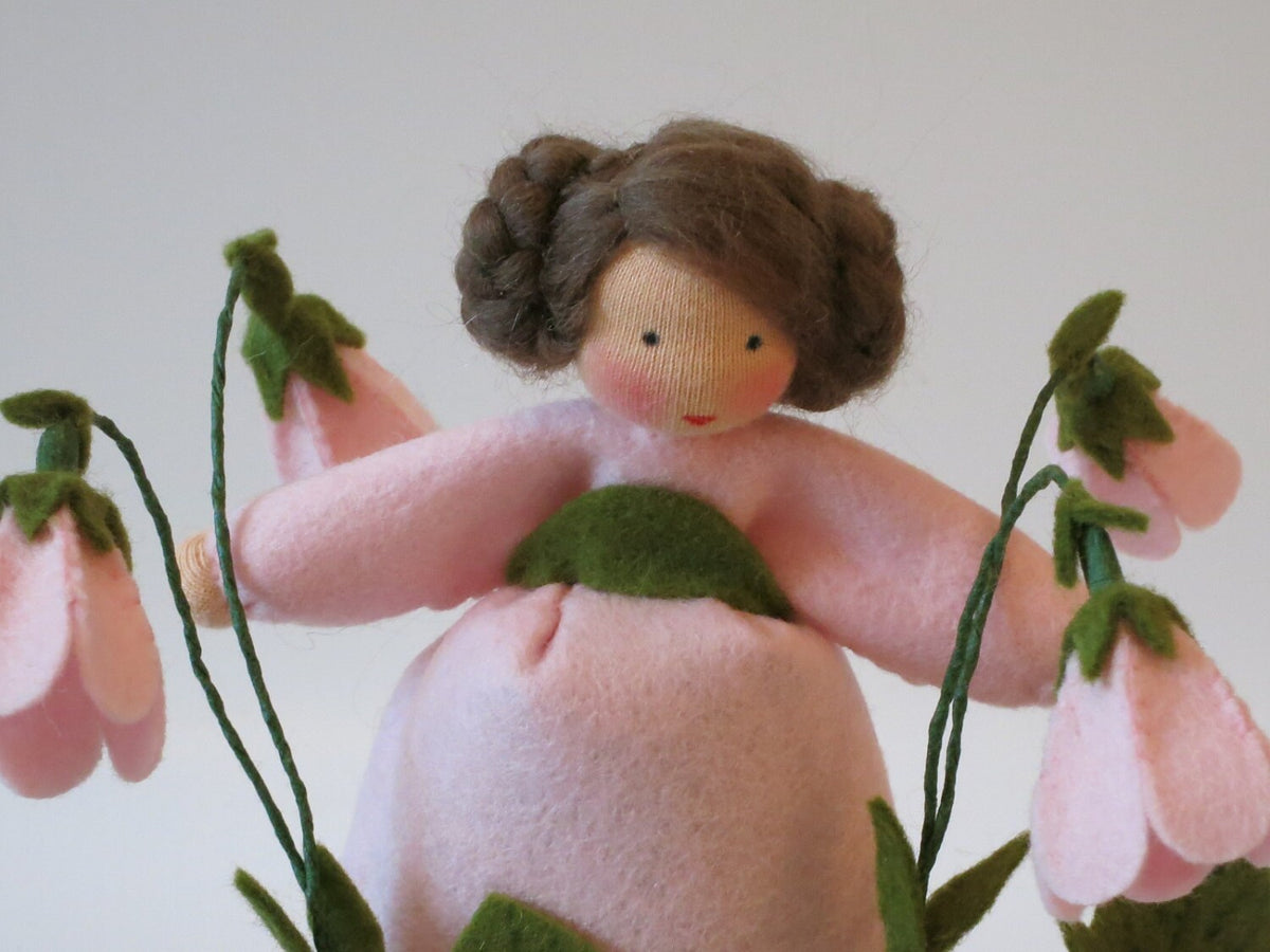 Nahaufnahme des Gesichts der Moosglöckchen-Figur mit geflöchtenen Zopfschnecken.