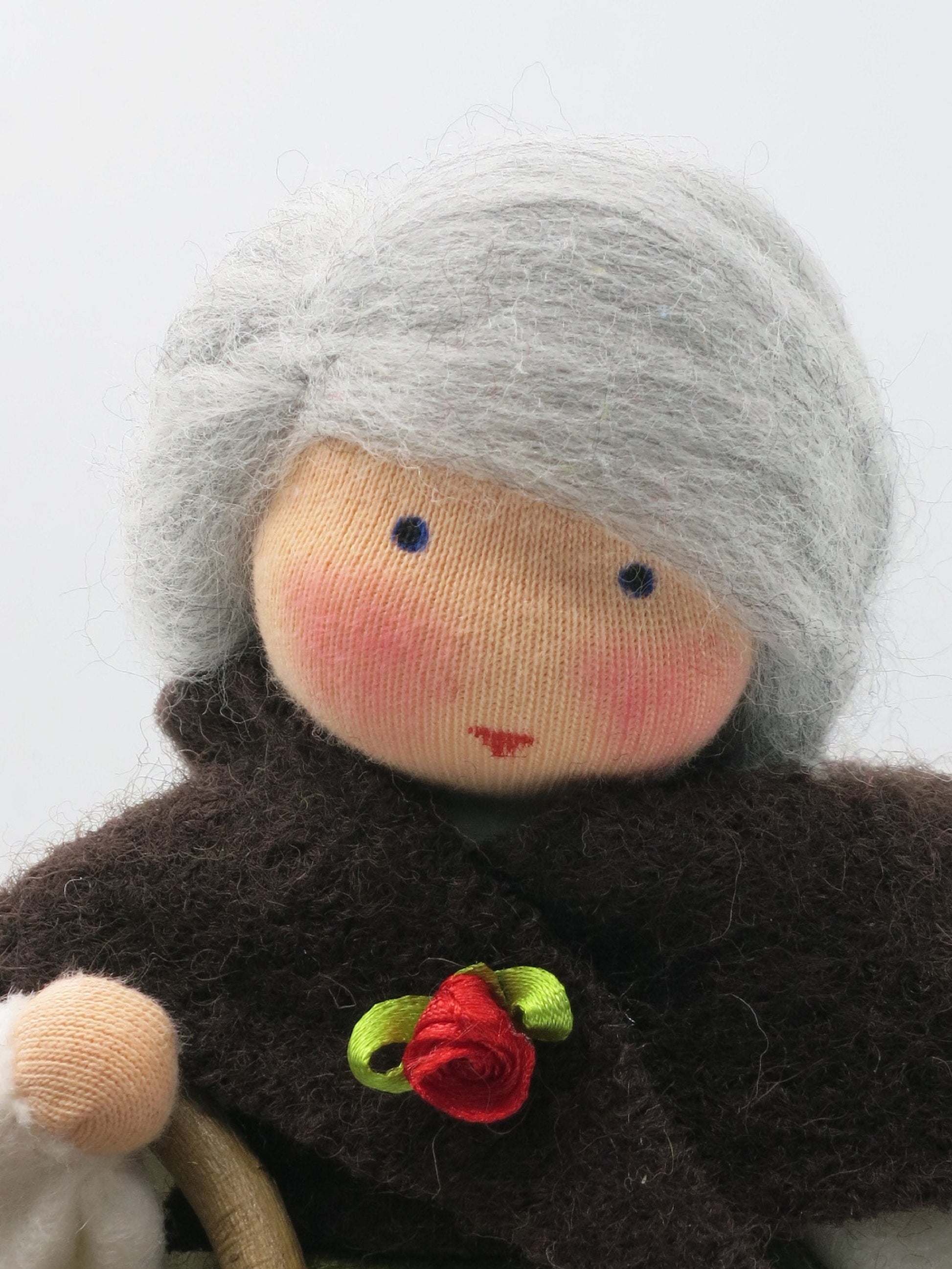 Mutter Erde Blumenkind aus Wollfilz, Nahaufnahme Gesicht mit roter Filzrosen-Brosche, Waldorf-Jahreszeitentisch, Art. HE3