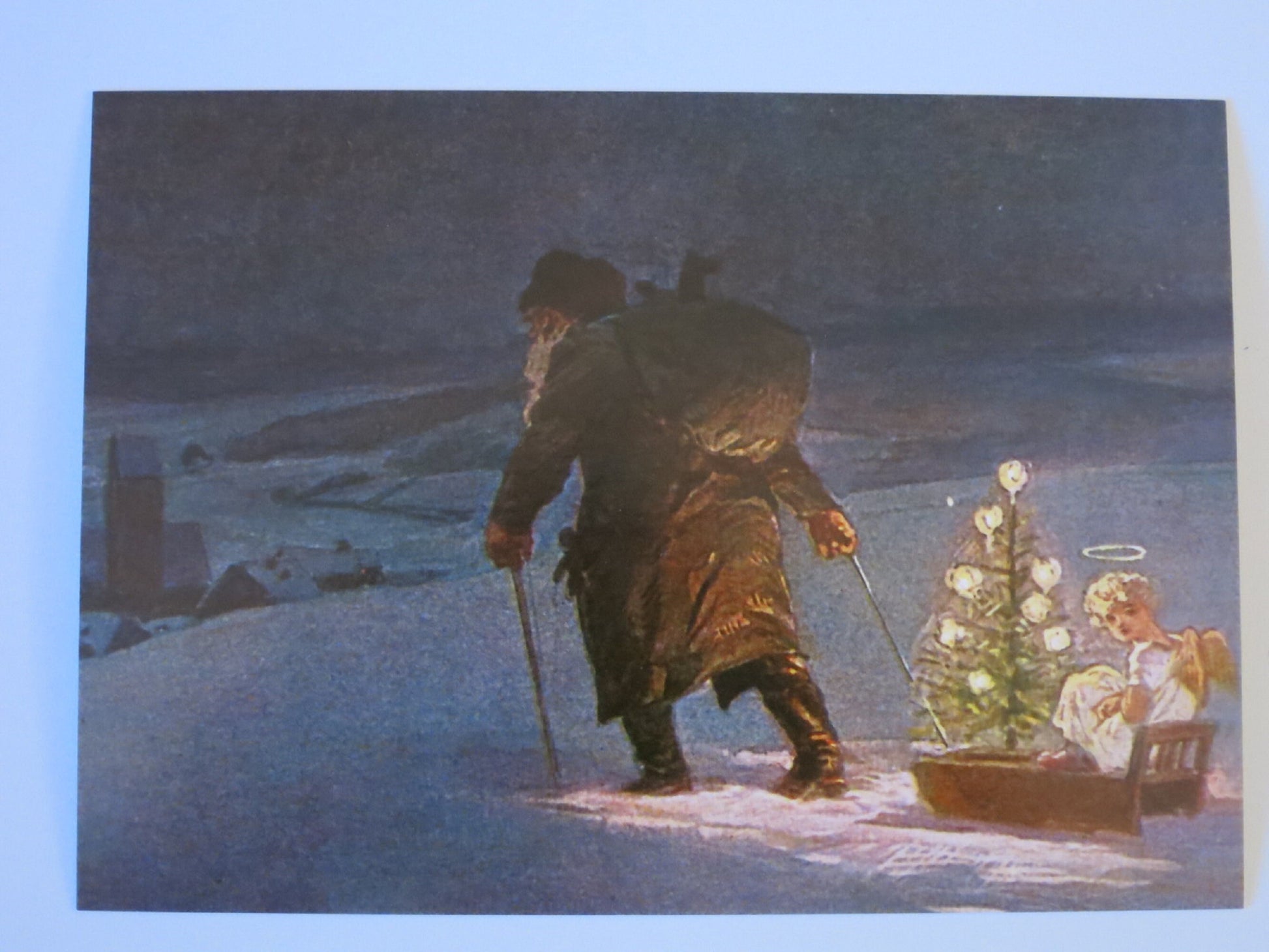 Nikolaus-Postkarte für Kinder: Knecht Ruprecht zieht Schlitten mit Engel und Lichterbaum durch verschneite Abenddämmerung