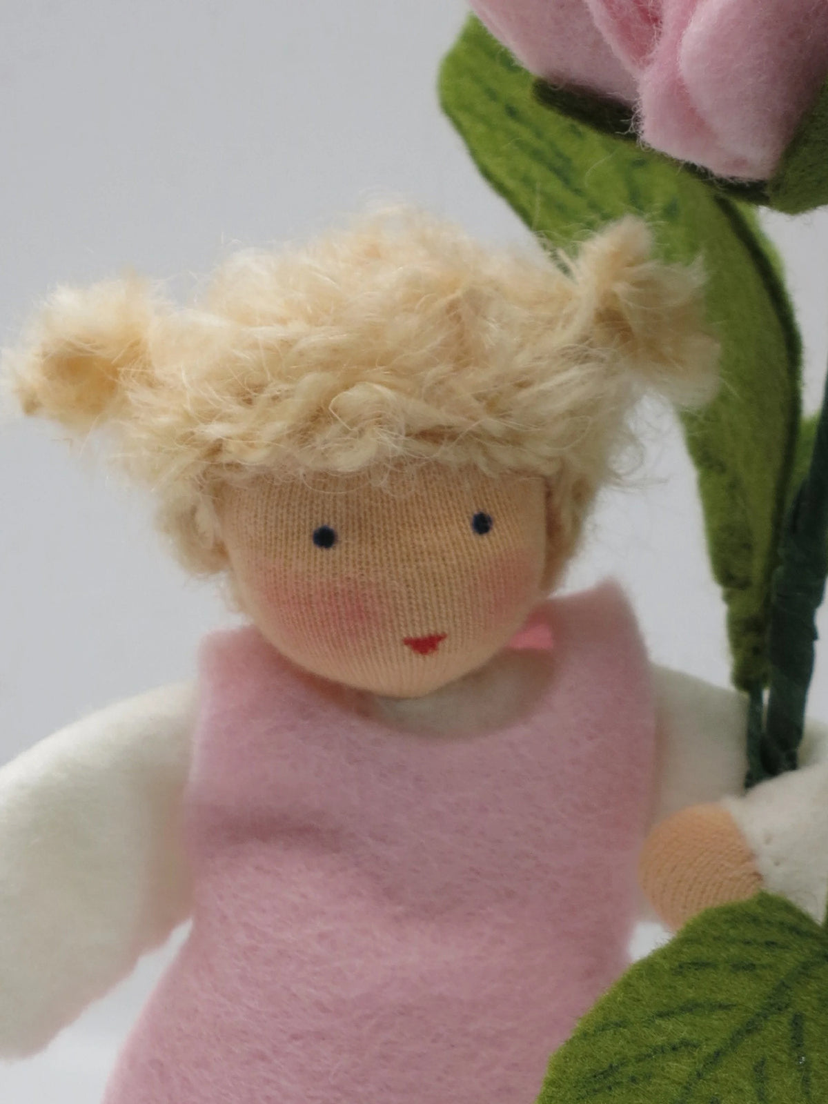 Nahaufnahme des Pfingstrose-Blumenkind-Gesichts mit blonden Zwillingsknoten