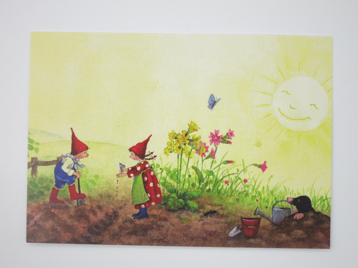 Postkarte Pippa und Pelle bei der Gartenarbeit von Daniela Drescher: Wichtelkinder graben und saeen im Beet, Maulwurf schaut zu