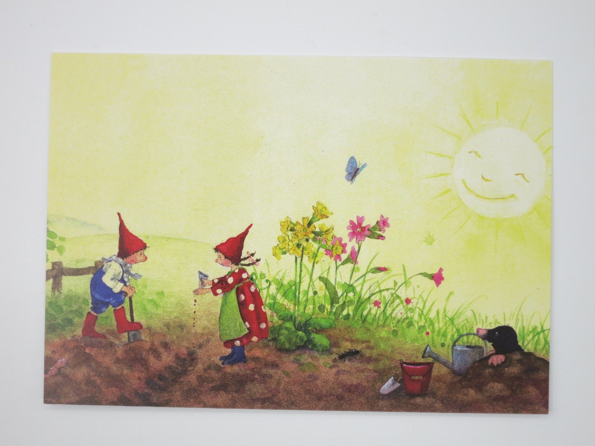 Postkarte Pippa und Pelle bei der Gartenarbeit von Daniela Drescher: Wichtelkinder graben und saeen im Beet, Maulwurf schaut zu