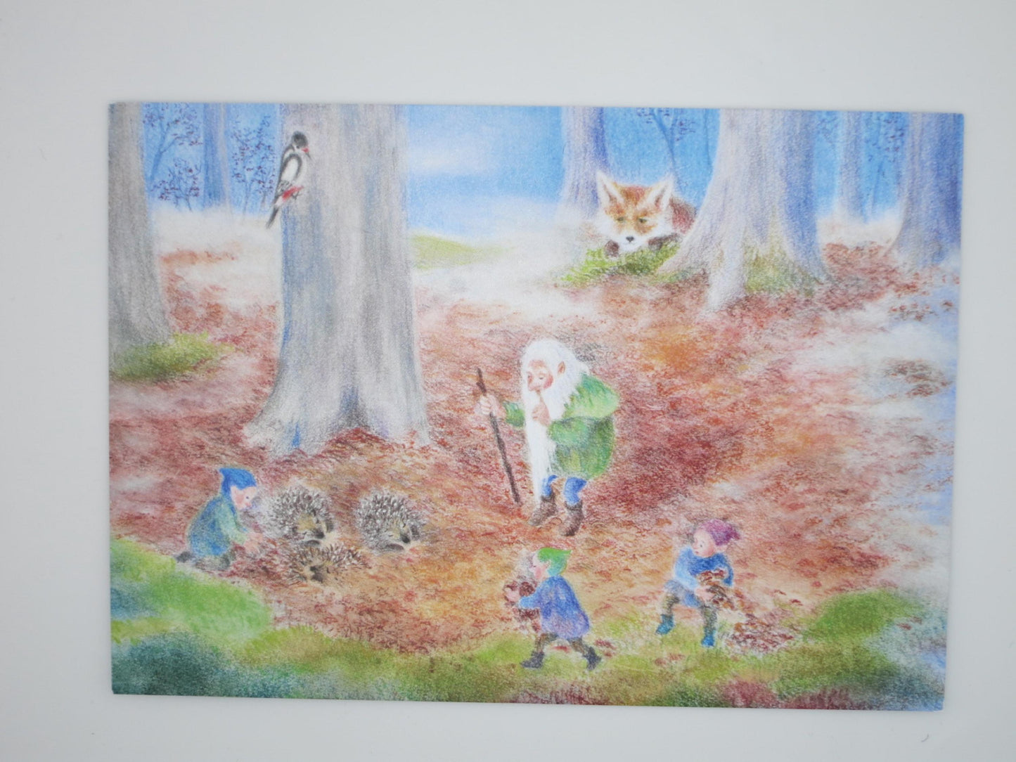 Postkarte Ein Igelbett aus Laub von Monika Speck: Zwerge sammeln Herbstlaub für zwei Igel