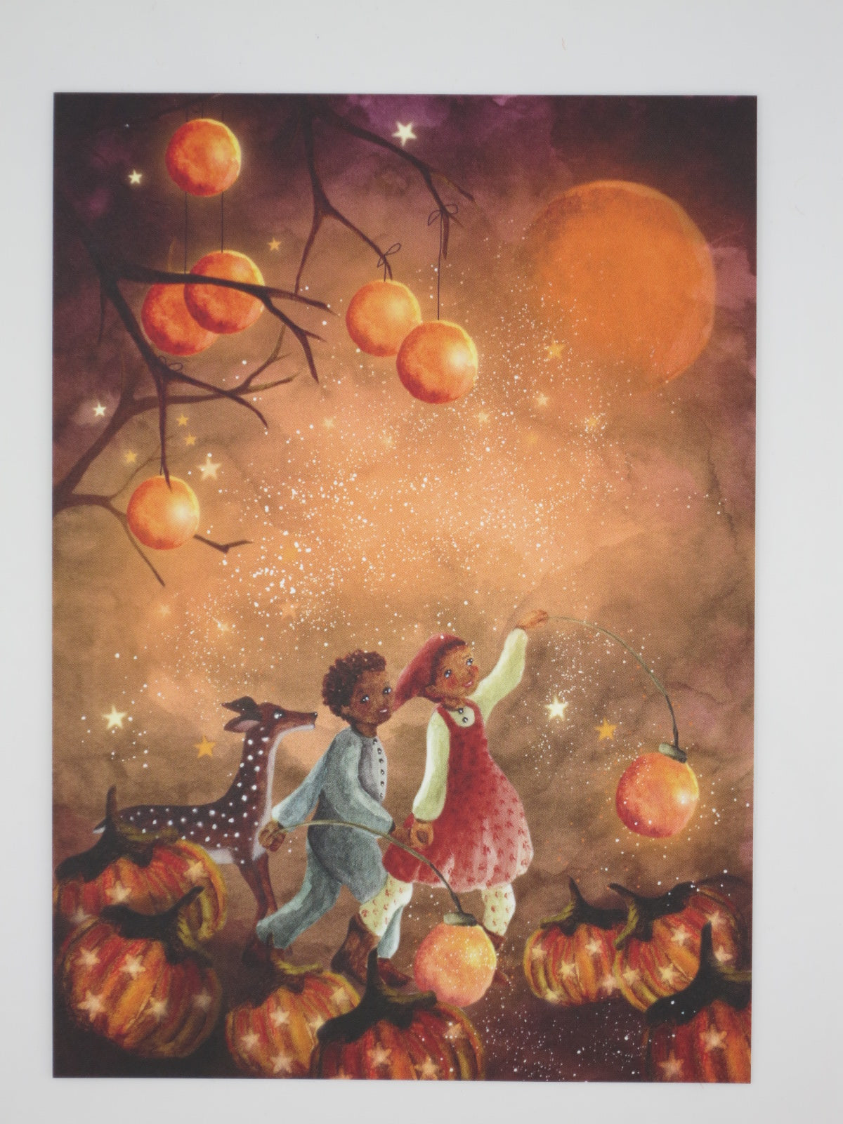 Postkarte Herbstlichter von Bijdehansje: Kinder mit Reh im leuchtenden Kürbisfeld