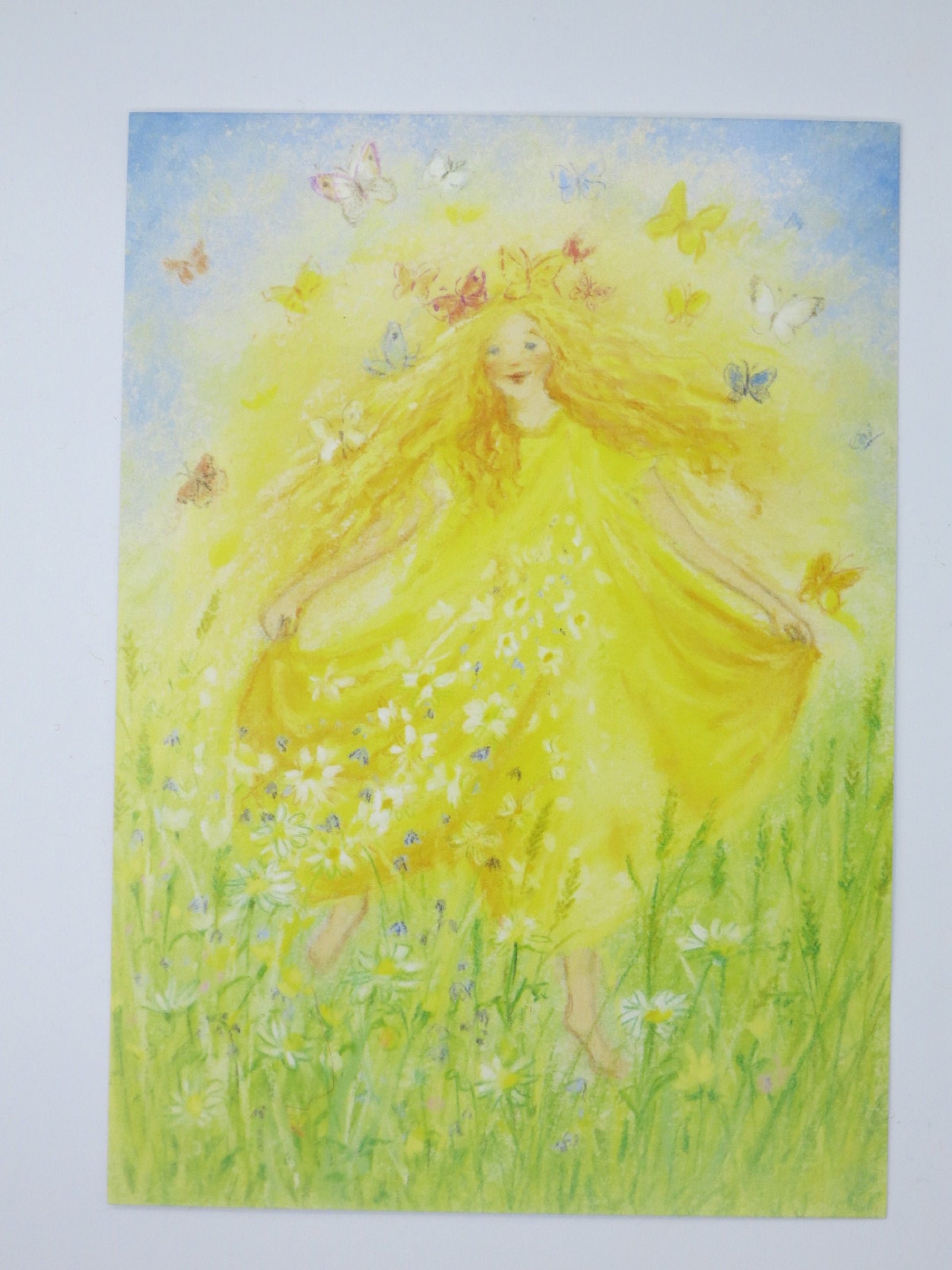 Waldorf Postkarte Der Frühling PKFR36: gelb gekleidete Frühlingsgestalt mit Schmetterlingen in Gaensebluemchenwiese, Design von Marjan van Zeyl