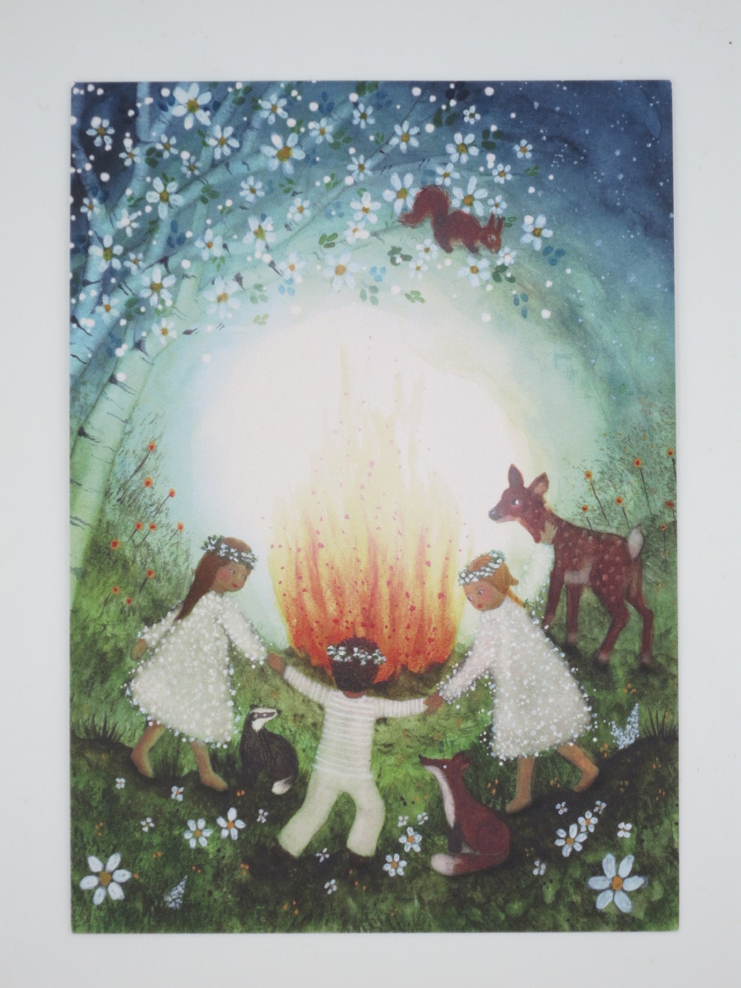 Postkarte Mittsommer: Kinder tanzen um Sonnwendfeuer mit Waldtieren, Illustration von Bijdehansje