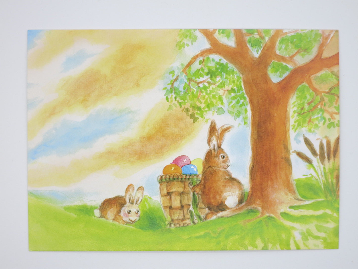 Waldorf Postkarte Osterhase PKFR76: zwei Hasen mit Eierkorb unter einem Baum bei Sonnenaufgang, Aquarell von Johanna Schneider