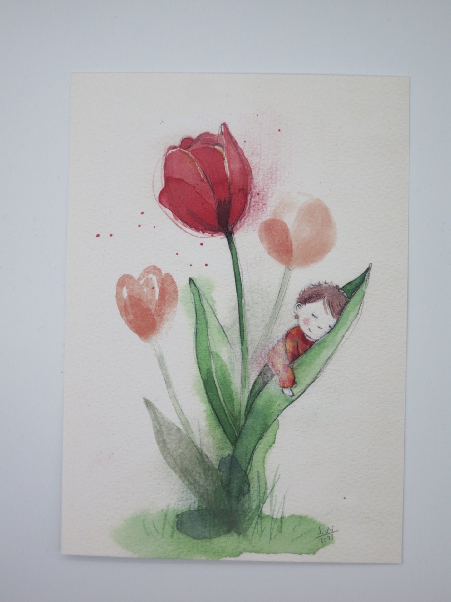 Waldorf Postkarte Tulpen PKFR169: schlafendes Kind in einem Tulpenblatt, umgeben von einer roten und zwei rosa-orangenen Tulpen, Aquarell von Stefanie Messing