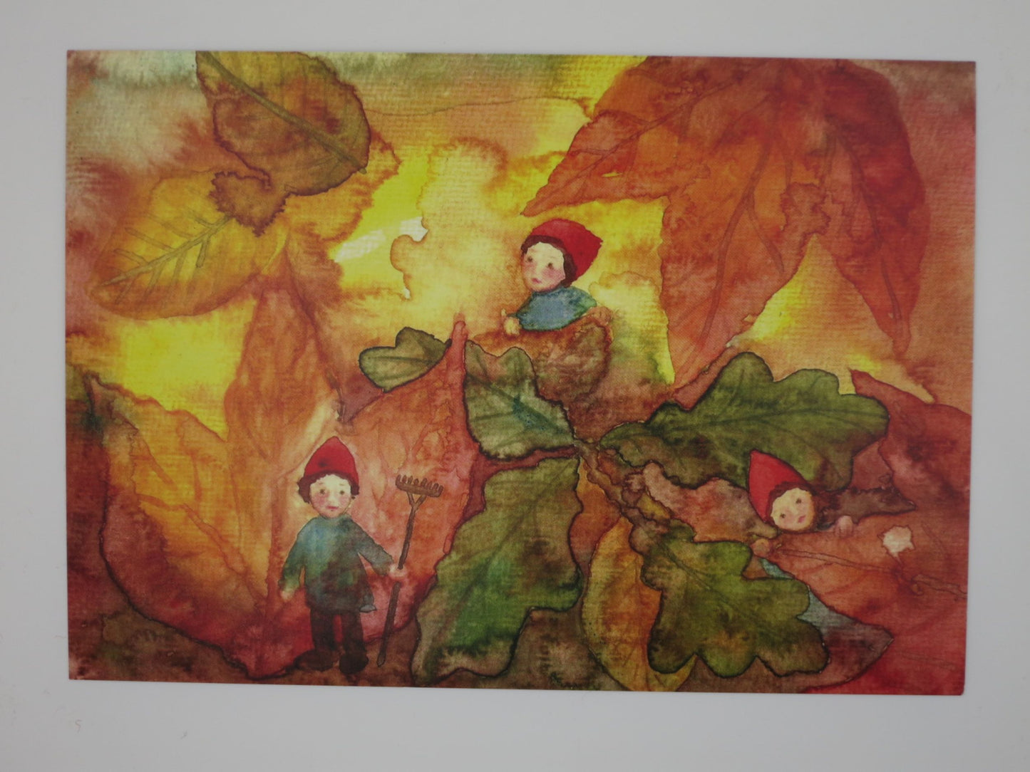 Herbst Postkarte Wichtel im Herbstlaub PKHE158: Wichtel zwischen riesigen Eichenblaettern mit Rechen, Aquarell von Anna Hunold