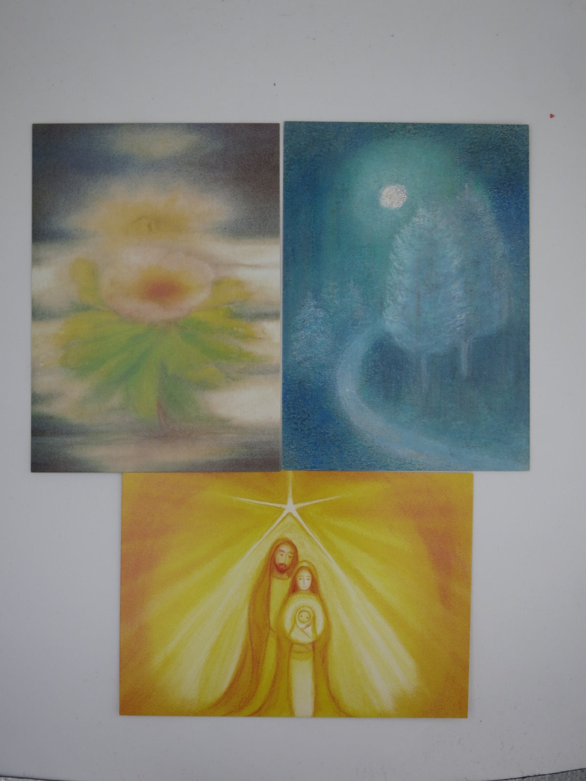 Drei Karten aus dem Postkartenset Winter in Pastellkreide: Lichtblüte, Winterbaum und Heilige Familie