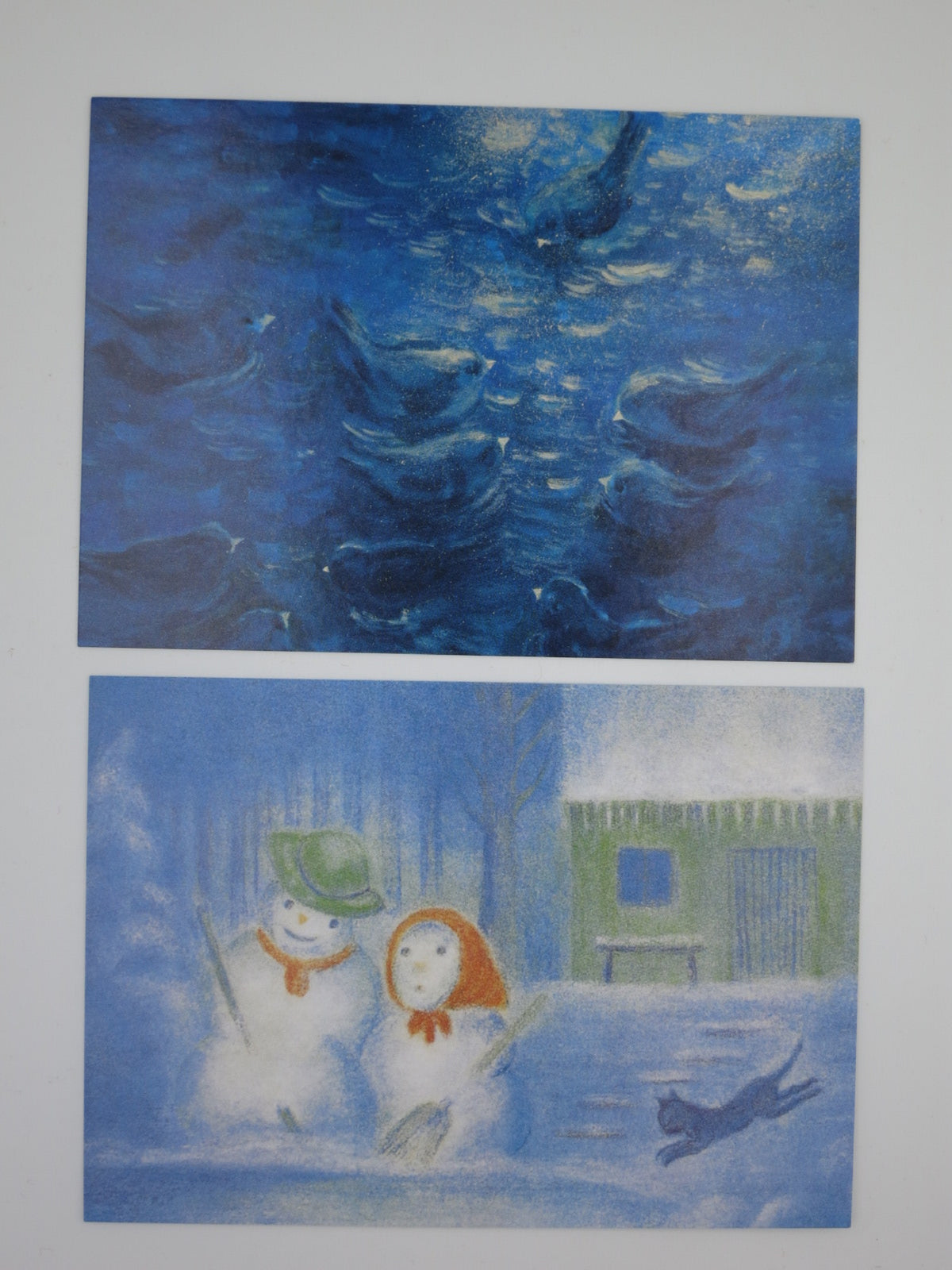 Zwei Karten aus dem Postkartenset Winter: blaue Nachtszene und Schneemänner