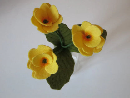 Nahaufnahme der gelben Primelblüten aus Filz am Primeljunge Waldorf Jahreszeitentisch Blumenkind
