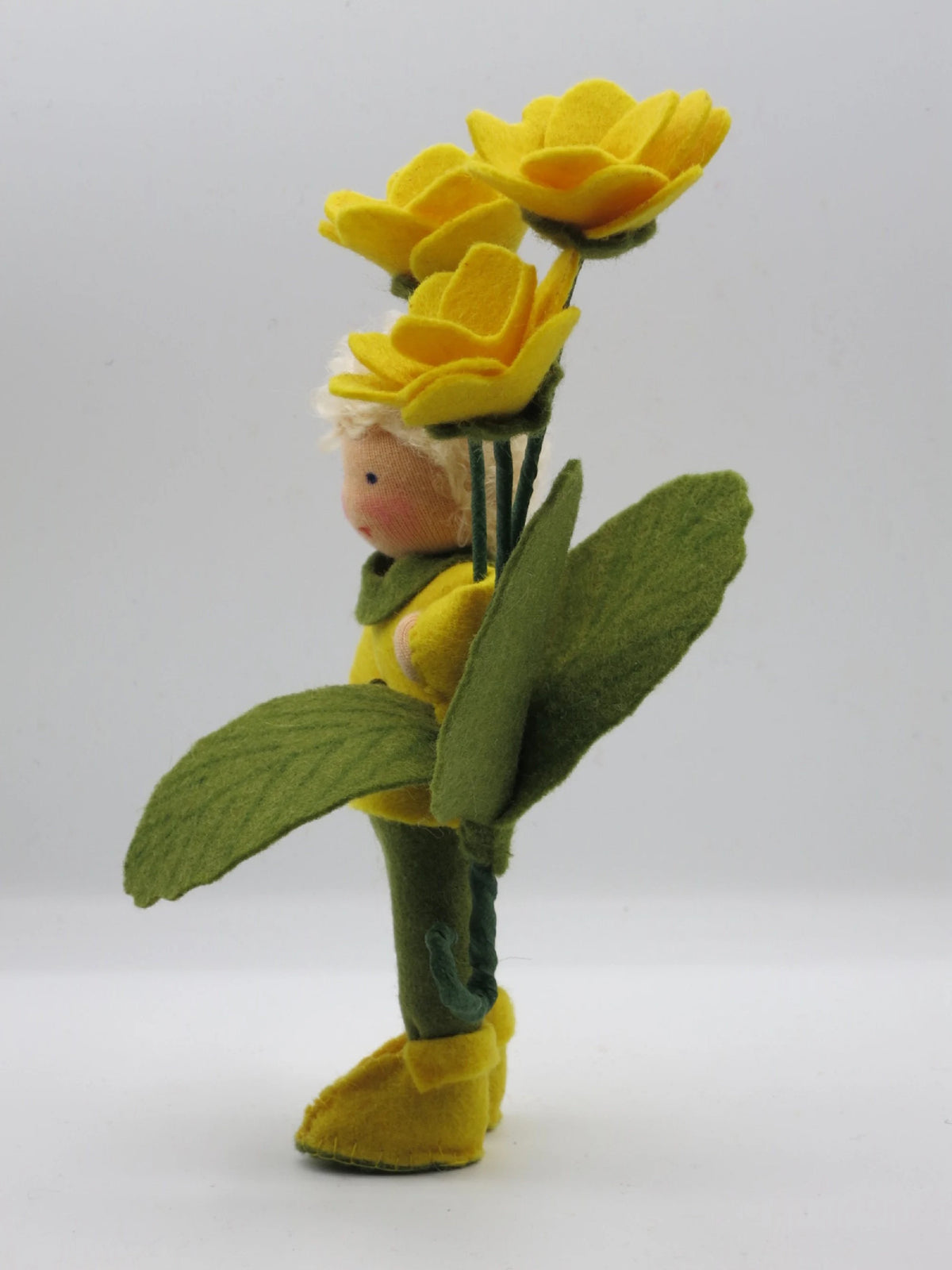 Seitenansicht des Primeljunge Blumenkindes mit gelben Stiefeln, Waldorf Jahreszeitentisch