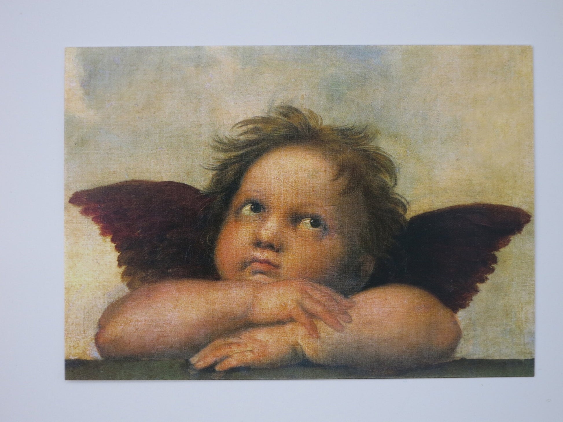 Nahaufnahme eines Engels aus Raffaels Sixtinischer Madonna, Kinn auf verschränkte Arme gestützt – Engel PKGR43