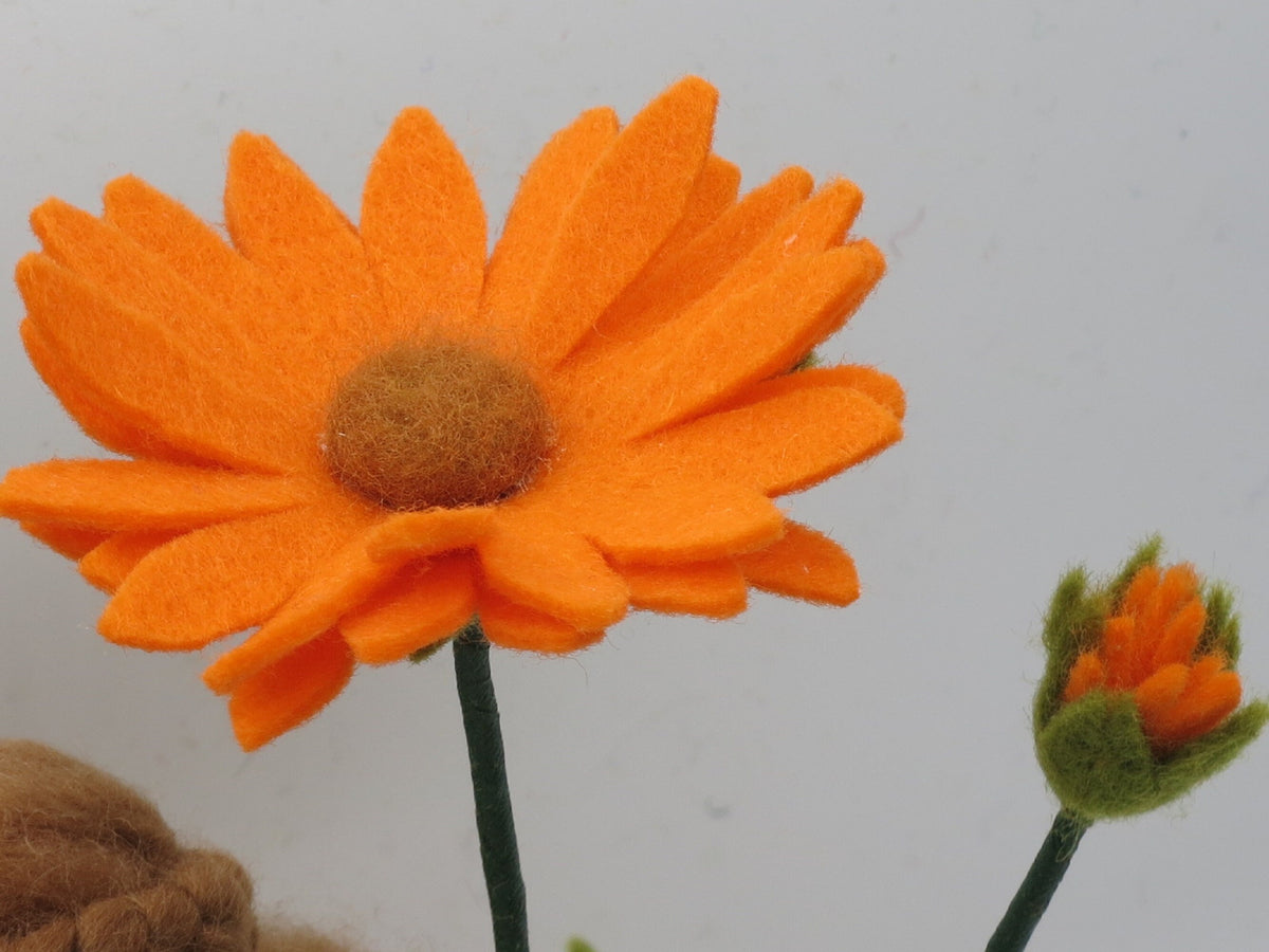 Nahaufnahme der Ringelblumen-Blüte mit Knospe daneben, Wollfilzfigur für den Jahreszeitentisch.