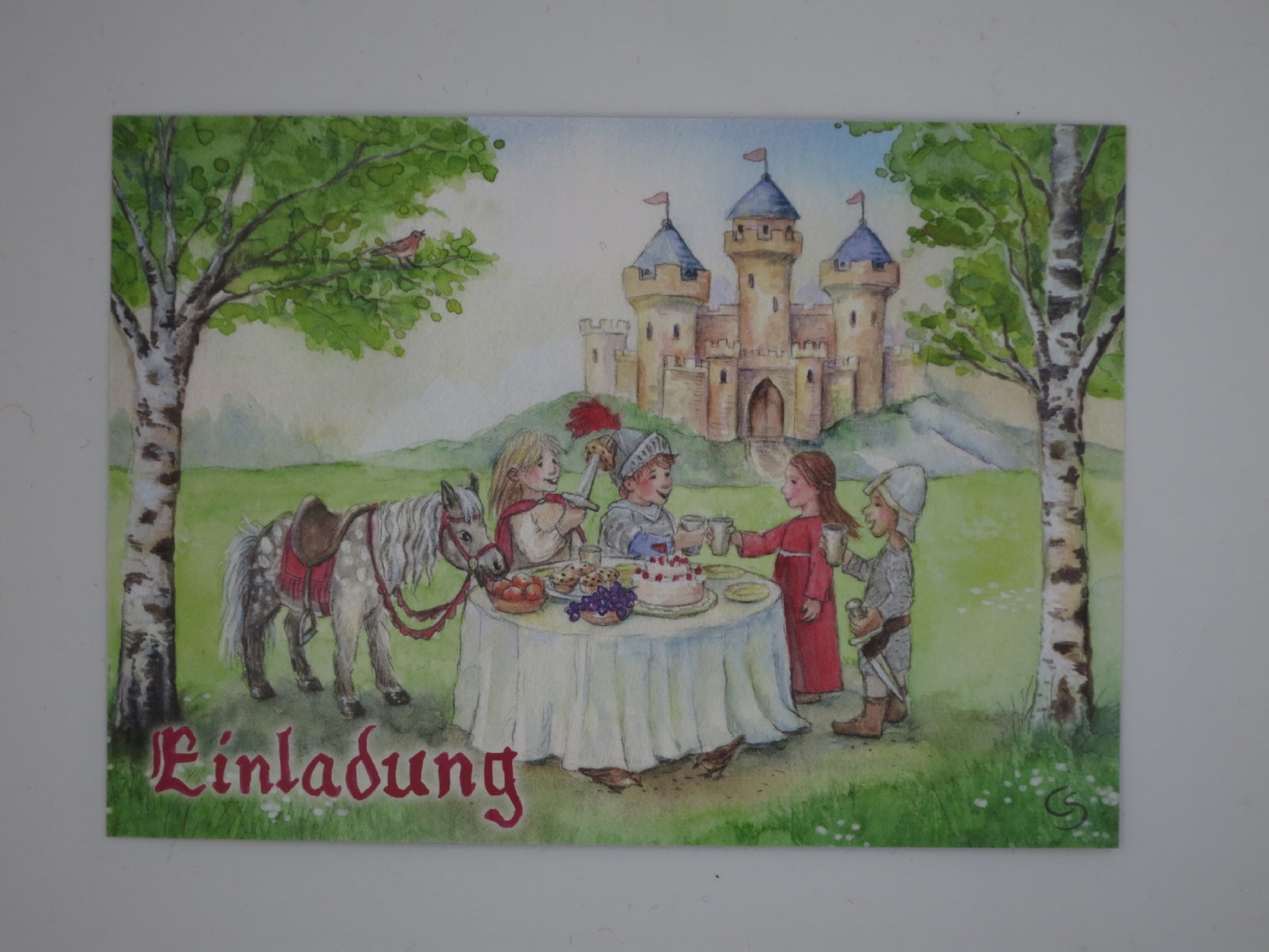 Ritter-Einladungskarte mit Kindern in Rüstung, Pony und Burg vor gedecktem Geburtstagstisch – Geburtstagseinladung Ritter GK29