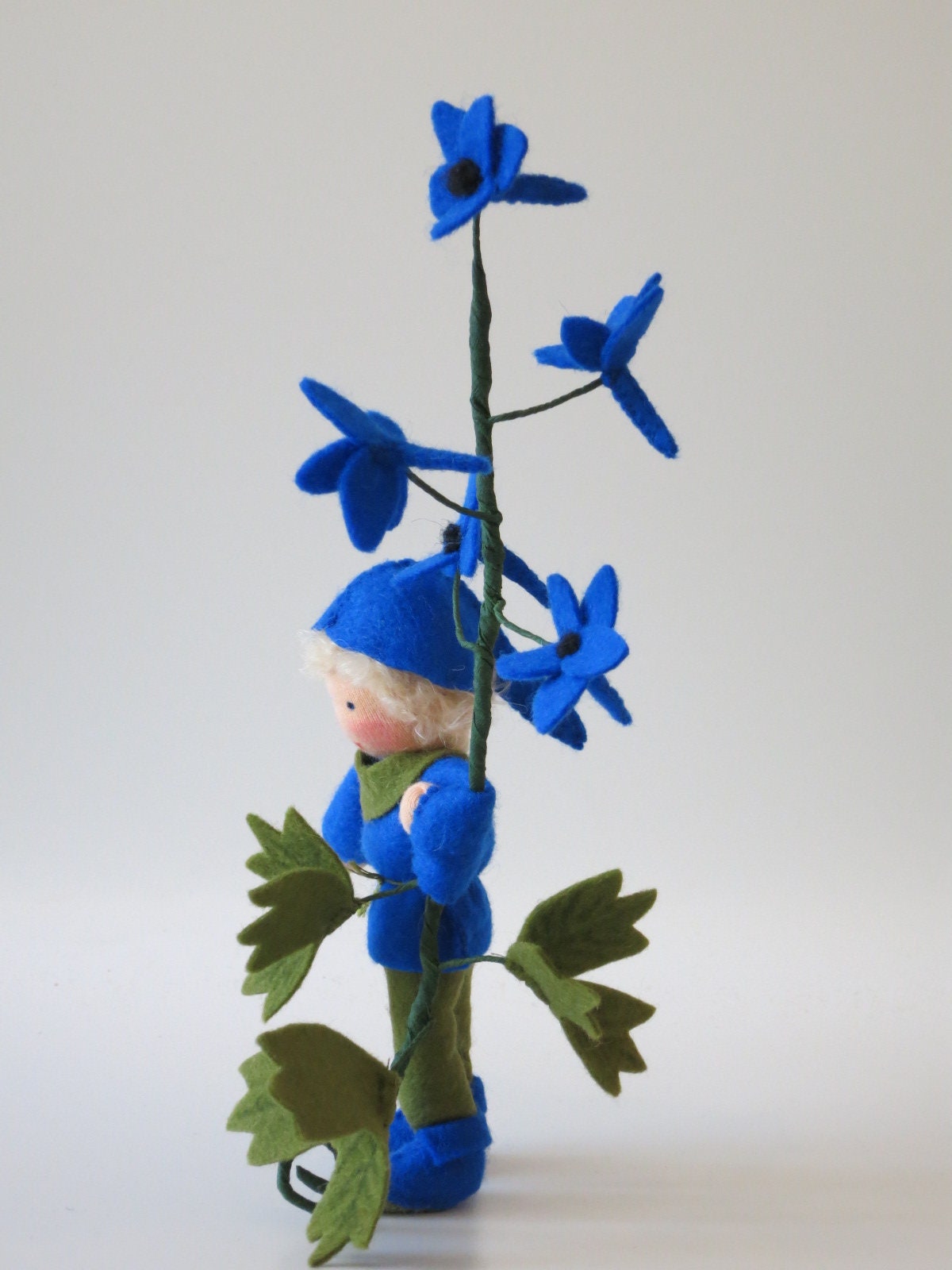 Profilansicht Rittersporn-Blumenkind aus Wollfilz mit blauem Blütenzweig, Waldorf-Wollfilzfigur