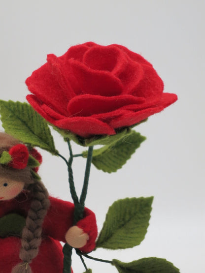 Detailaufnahme der roten Filzrose mit grünem Blattzweig am Waldorf-Blumenkind