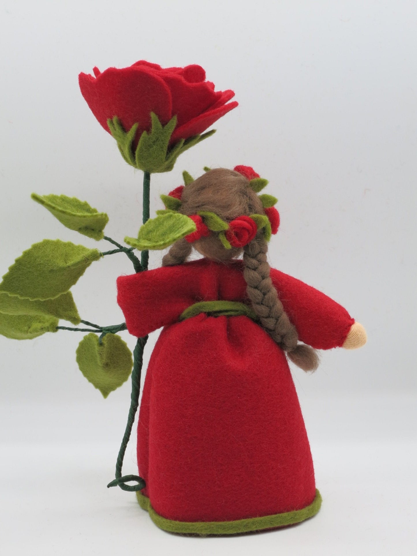 Rückansicht des Rose-Blumenkindes mit vollem Rosenkranz im Zopf, Waldorf-Jahreszeitentisch Sommer